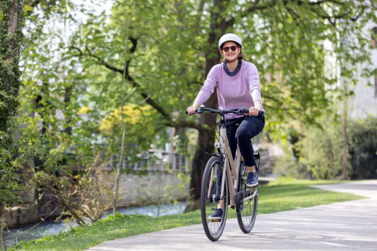 Aktive Seniorin mit unsichtbarem Hörgerät beim Fahrradfahren