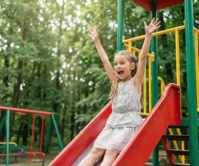 Glückliches Kind auf dem Spielplatz – Schwerhörigkeit bei Kindern rechtzeitig erkennen